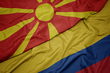 waving colorful flag of colombia and national flag of macedonia.