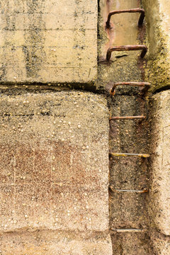 Beadnell, Northumberland, England UK - Rusty steps set in a weathered harbour wall at low tide with limpets and barnacles encrusting the wall.
