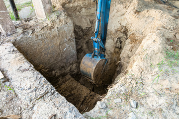Bucket excavator digs soil at construction site. Construction hydraulic equipment.