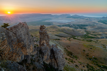 Obraz premium Sunset landscape with rocks and hills valley