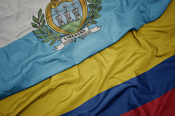 waving colorful flag of colombia and national flag of san marino.