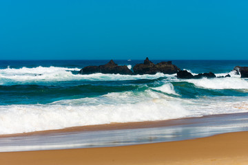 Big breaking Ocean wave on a sandy beach