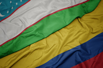 waving colorful flag of colombia and national flag of uzbekistan.