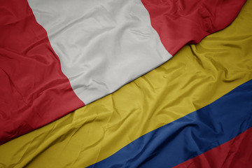waving colorful flag of colombia and national flag of peru.