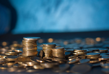 Banking and money trading. Golden metal coins stacked in different combinations on dark blue blurred background. Serbian metal coin, copy space