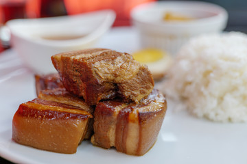 Close up view of Kakuni, Japanese Braised Pork Belly, with rice and soup on white plate. 