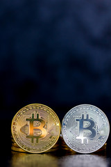 silberne und goldene Bitcoin Münzen vor dunklem Hintergrund (virtuelles Geld oder Kryptowährung)