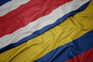 waving colorful flag of colombia and national flag of costa rica.