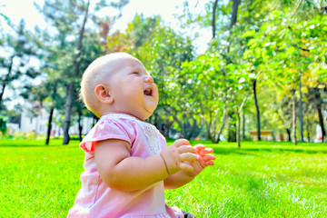 A child on the green grass is played in the park.