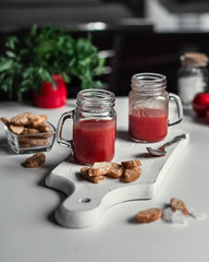 Fresh tomato juice in glasses on a white wooden board, bread croutons. Vegetarianism, healthy...