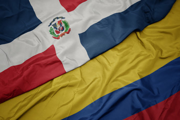 waving colorful flag of colombia and national flag of dominican republic.