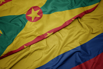 waving colorful flag of colombia and national flag of grenada.