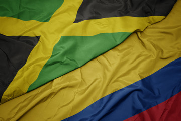 waving colorful flag of colombia and national flag of jamaica.