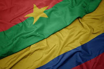 waving colorful flag of colombia and national flag of burkina faso.