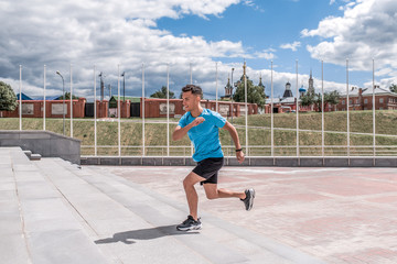 Male athlete running jogging fitness workout workout, jogging morning in summer in the city. Sportswear Sneakers Shorts. Active youth lifestyle. Free space for motivation text.