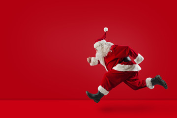 Fototapeta na wymiar Santa Claus runs fast on red background