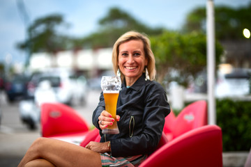  woman sitting at the table and drinking a beer.