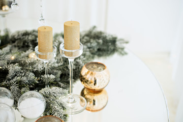 New Year's festive glass table setting. Greeting card. There are wine glasses and cutlery in the branches of the Christmas tree. Decorated with gold candles, deer, stars, balls. Copy space, bokeh fir