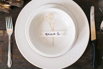 Modern table setting with name tag, event or wedding table with plate, bowl, and silverware