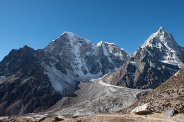 Hiking trail through the Himalayan mountains of Nepal surrounded by receding glaciers and dry rocky terrai