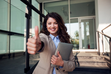 Happy business woman showing like or thumb-up