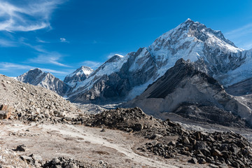 Hiking trail through a valley in the Himalayan mountains of Nepal surrounded by rocky terrain and glaciers