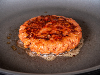 Charred and ready to eat plant-based burger in frying pan