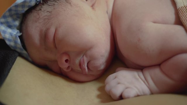 image of little newborn baby sleeping on mother's chest