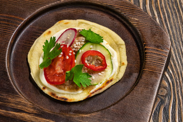 Mexican cuisine, taco with tomato, cucumber and pepper on wooden tray