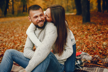Fototapeta premium Couple in a park. Family in a golden forest. Man with a beard