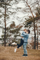 gentle and stylish couple are having a walk in the autumn park