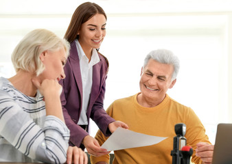Female notary working with mature couple in office