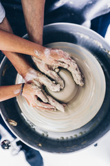 Happy mother and daughter making clay pottery on a spin wheel. .