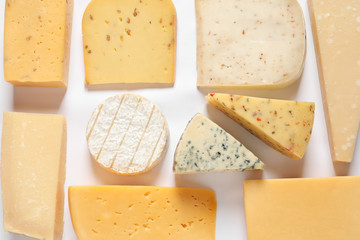 Composition with different kinds of tasty cheese on white background, top view