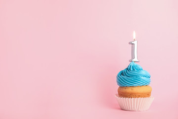 Birthday cupcake with number one candle on pink background, space for text