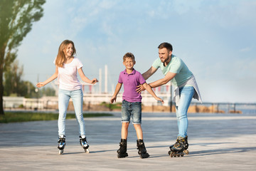 Obraz premium Happy family roller skating on city street