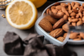 Different products with magnifier focused on almonds, closeup. Food allergy concept