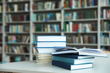 Stack of books on white table in library