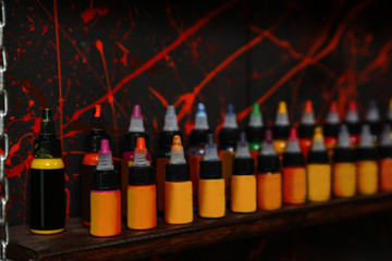 Bottles of inks on shelf in tattoo salon