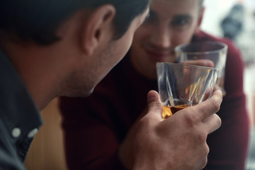 Young men drinking whiskey together in bar