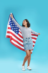 happy young woman with USA flag on blue background