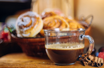 Cinnamon rolls with coffee on wooden table