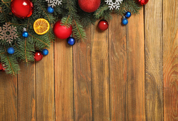 Fir branches with Christmas decoration on wooden background, flat lay. Space for text