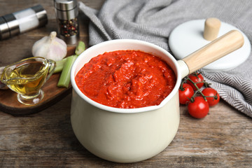 Pan of tomato sauce on wooden table