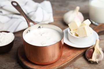 Delicious creamy sauce in pan on wooden table