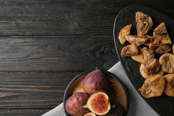 Tasty dried and raw figs on black wooden table, flat lay. Space for text