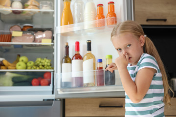 Girl feeling bad smell from stale products in refrigerator at home