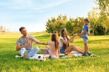 Happy family having picnic in park on sunny summer day