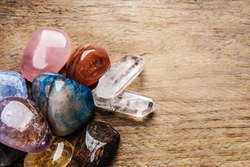 Flat lay composition with different gemstones on wooden table, space for text