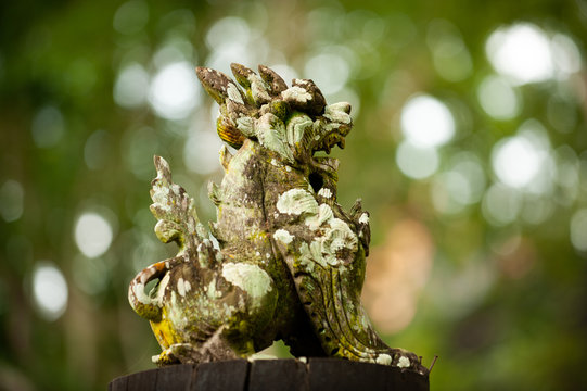 The stone lion statues in Thai literature are displayed in the park for tourists. It's old and has moss.